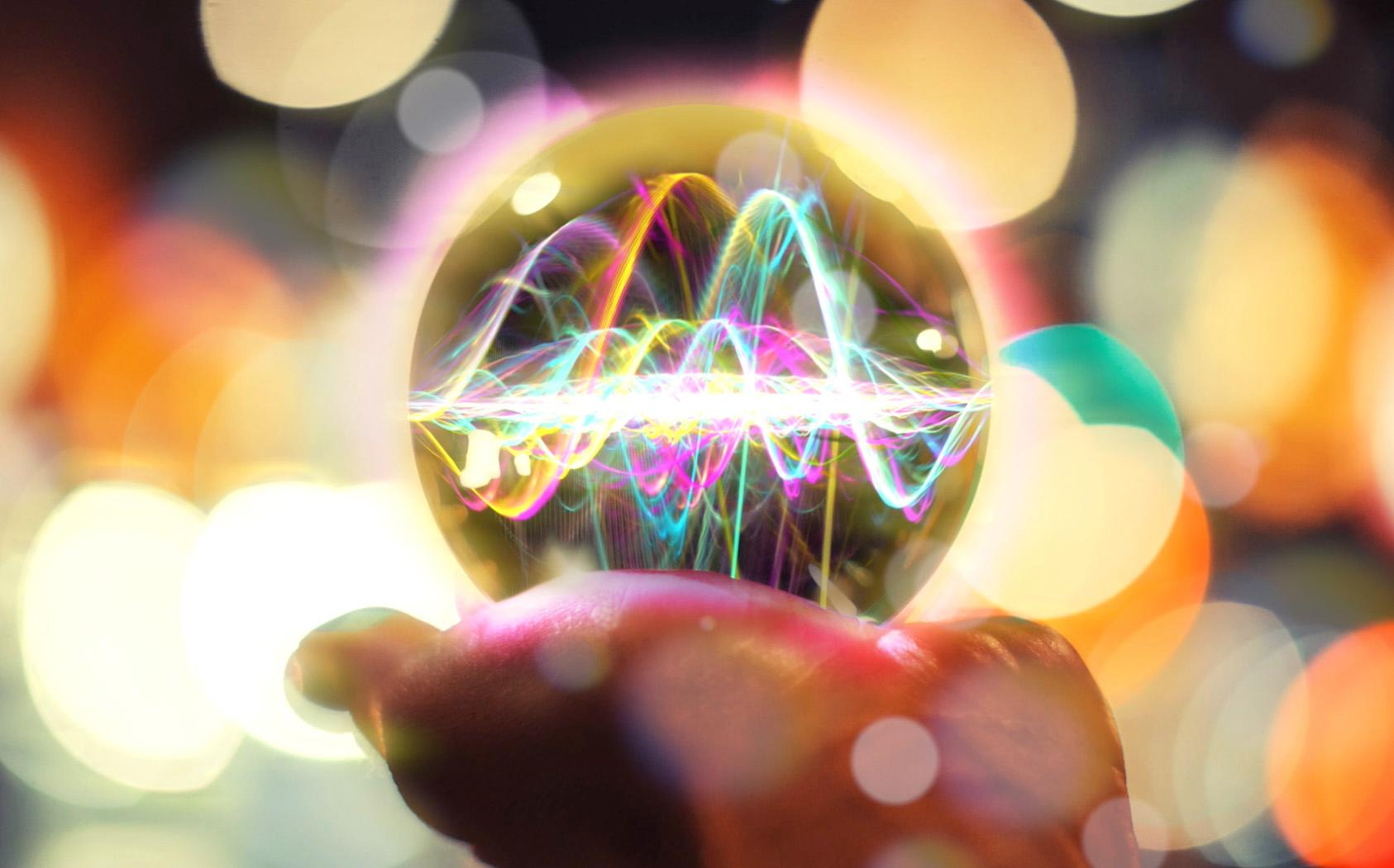 Image of a woman holding a crystal ball with sound waves visible