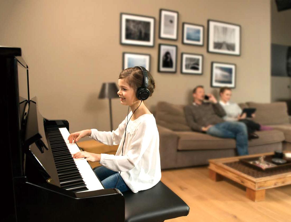 Yamaha Silent piano being played by a girl whilst her mother is on the phone and her dad uses an iPad