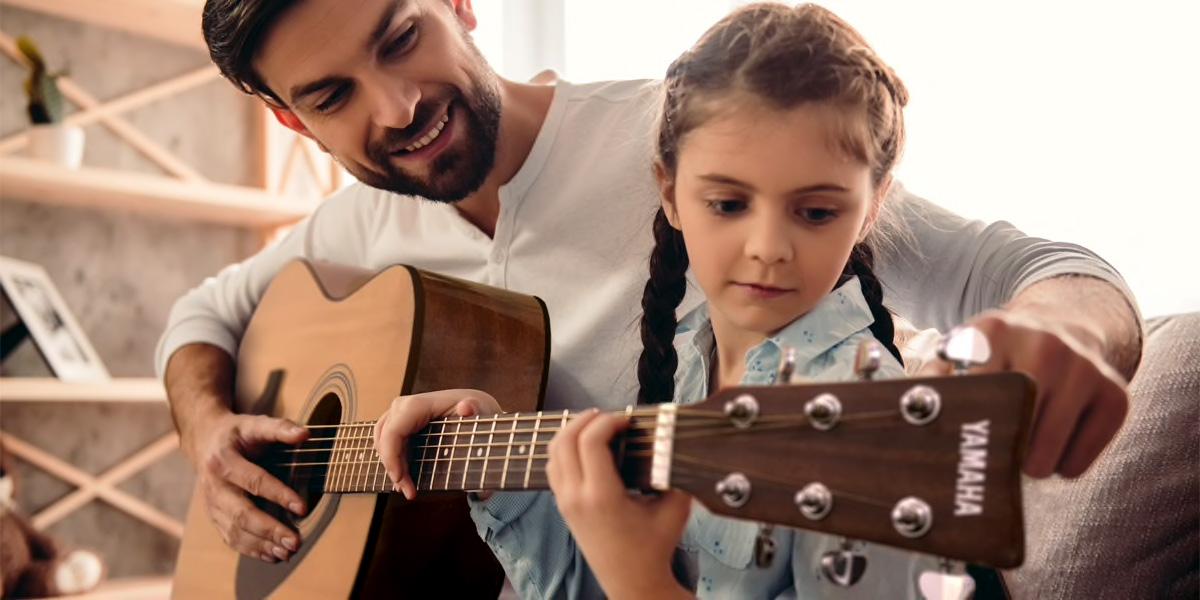 A father showing his daughter the F310 guitar
