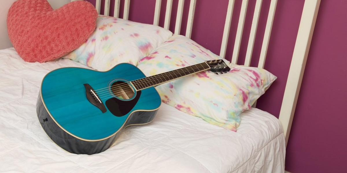 A bright blue GS820 guitar on a bed