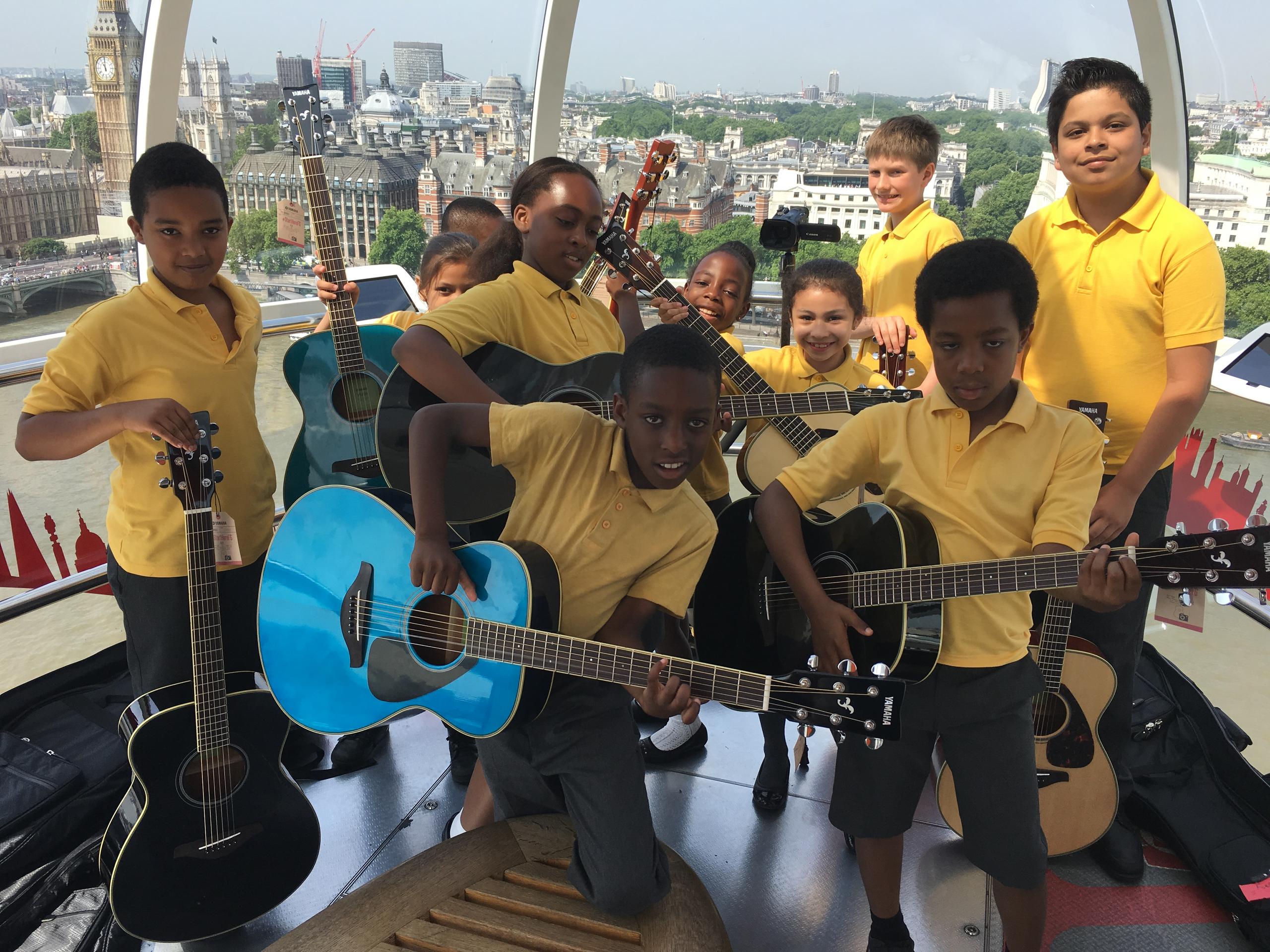 Yamaha Music London holds a guitar lesson on the London Eye with pupils from St George's Cathedral Catholic Primary School